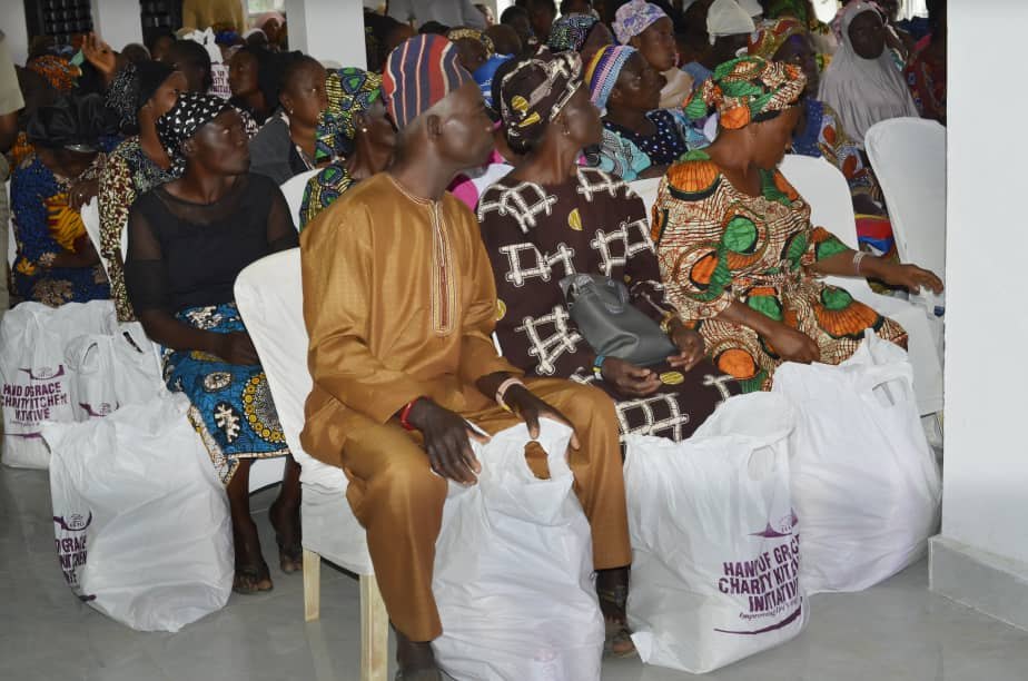 Community members seated with Hand of Grace food packs