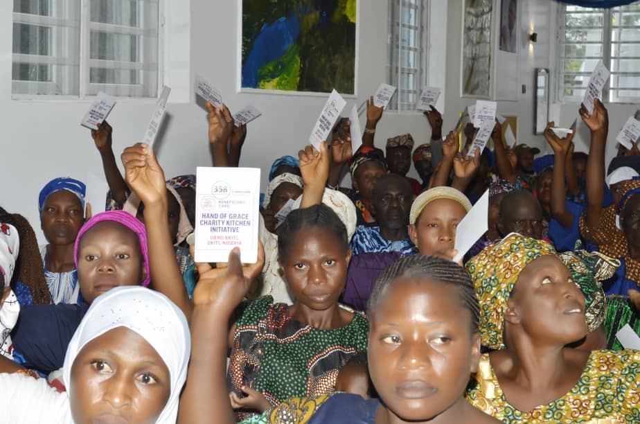 Community members holding their Hand of Grace verification cards