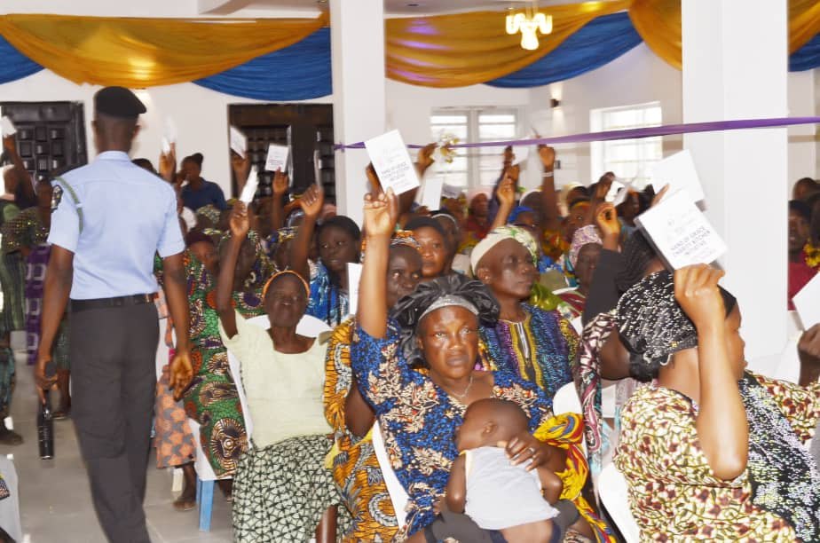 Community members holding their verification cards during the programme