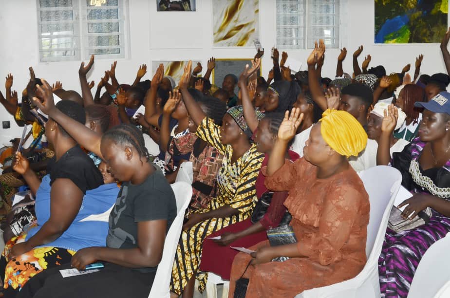 Community members raising their hands during Hand of Grace outreach